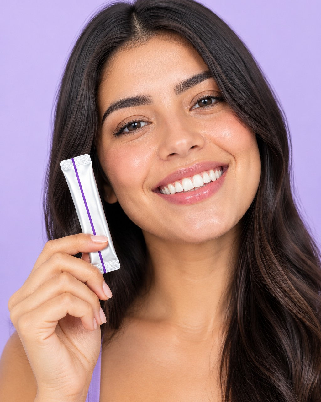 Mujer sonriendo con un sobre de enjuague blanqueador púrpura
